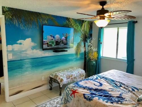 a bedroom with a painting of the ocean on the wall at 2 Bedroom , 2 Bath , Villa in Oldsmar