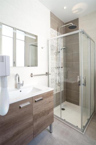 a bathroom with a glass shower and a sink at Les cles du 27 Paris in Paris