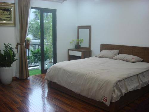 1 dormitorio con 1 cama grande y espejo en Lea House Ha Long, en Ha Long
