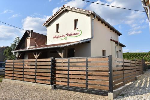 a building with a fence in front of it at Ubytovani Valentovi in Velké Bílovice