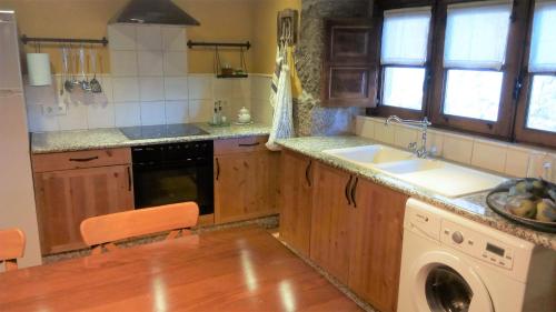 a kitchen with a sink and a washing machine at Casa Darío in Diomondi