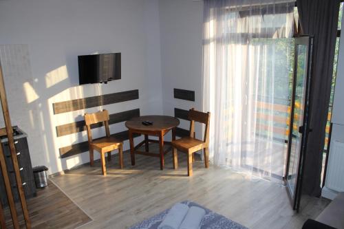 a room with a table and chairs and a television at Guest House on Meskheti in Borjomi