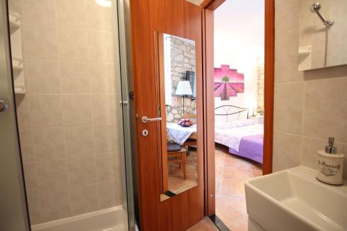 a bathroom with a shower and a bedroom at Studio Driovier 11 in Rovinj