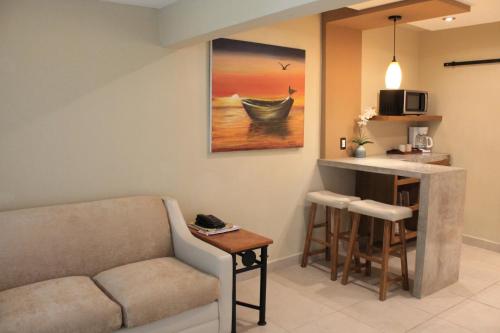 a living room with a couch and a kitchen with a table at Hotel Hacienda del Viejo in Matamoros