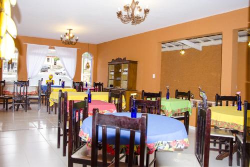 a restaurant with tables and chairs with colorful tables at Hotel Gandhi in Jacutinga