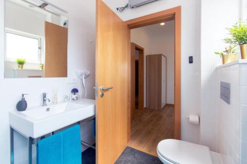 uma casa de banho com um lavatório, um WC e um espelho. em Friends & Family Tree no Porto
