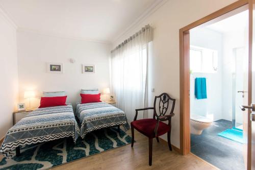 um quarto com uma cama e uma cadeira vermelha em Friends & Family Tree no Porto