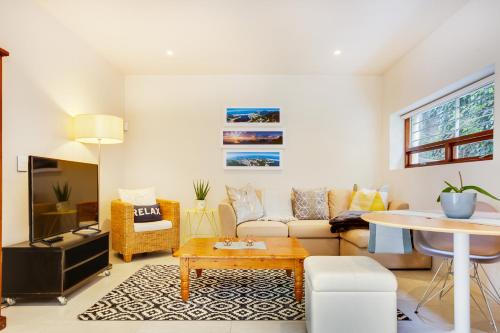 a living room with a couch and a table at Cheviot Place Garden Apartment with Private Entrance in Cape Town