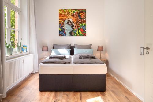 a bedroom with a bed with a painting on the wall at TOP-Lage, 400 m bis GOP, Bali-Therme und Kurpark - HDZ - Parkplatz, Netflix, Disney in Bad Oeynhausen