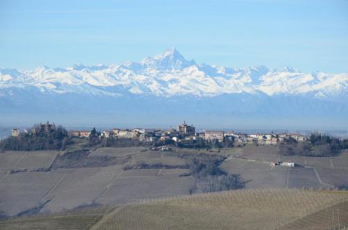 a town on a hill with a mountain in the background at Palazzo d'Assi - Guest house in Monforte dʼAlba