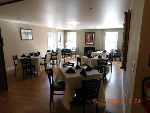 a dining room with white tables and chairs at Freeport Wine Country Inn in Freeport