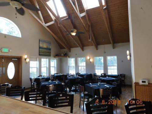 a dining room with blue tables and chairs and windows at Freeport Wine Country Inn in Freeport