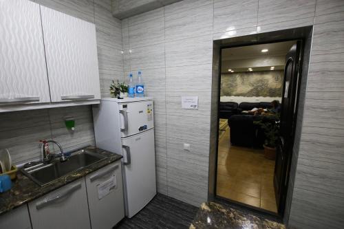 a kitchen with a sink and a refrigerator at Apple Hostel Bishkek in Bishkek