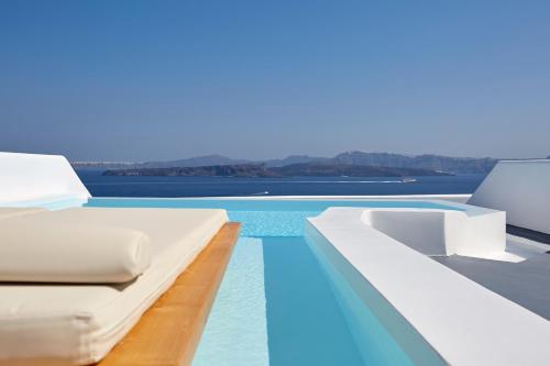 a bed on the edge of a swimming pool at Phos The Boutique in Akrotiri