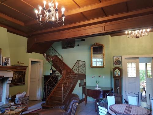 a staircase in a living room with a chandelier at Château Lambert Moulinsart Hotel, shuttle airport, long term parking, snooker, large terrasse, dinner, breakfast in Charleroi