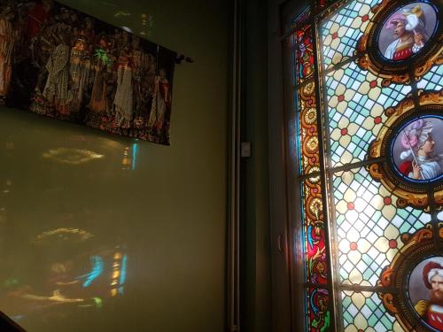 a stained glass window with pictures on a wall at Château Lambert Moulinsart Hotel, shuttle airport, long term parking, snooker, large terrasse, dinner, breakfast in Charleroi