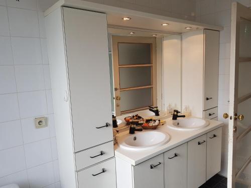 ein Badezimmer mit 2 Waschbecken und einem Spiegel in der Unterkunft Château Lambert Moulinsart Hotel, shuttle airport, long term parking, snooker, large terrasse, dinner, breakfast in Charleroi