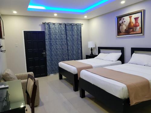 a hotel room with two beds and a blue light at Christar Villas Hotel in Kingston