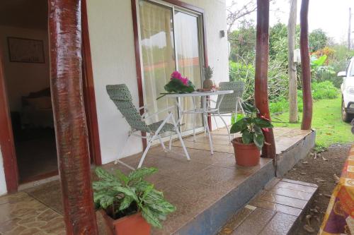 a porch of a house with a table and chairs at Cabañas Peretei in Hanga Roa