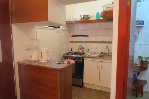 a small kitchen with a stove and a sink at Cabañas Peretei in Hanga Roa