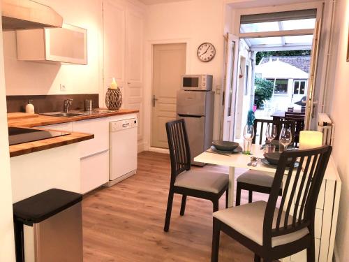 une cuisine avec une table, des chaises et un réfrigérateur dans l'établissement maison Vendeuvre sur barse, à Vendeuvre-sur-Barse