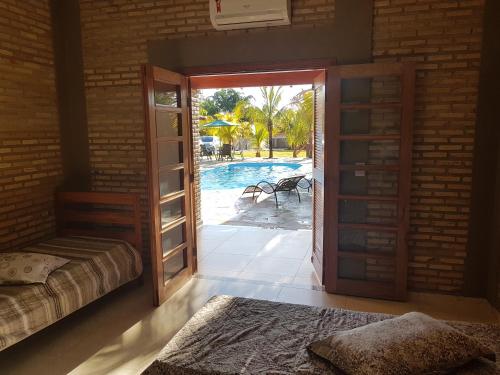 Schlafzimmer mit einer Tür zum Pool in der Unterkunft Chacara Recanto dos Pássaros 03 in Olímpia
