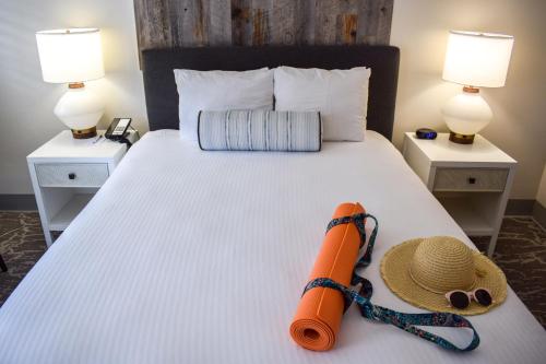 a bed with a hat and a straw hat and sunglasses on it at Beachside Inn in Santa Barbara