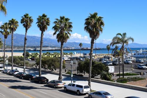 a parking lot with palm trees and a harbor at Beachside Inn in Santa Barbara