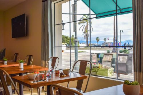 ein Restaurant mit Tischen und Stühlen und einem großen Fenster in der Unterkunft Beachside Inn in Santa Barbara