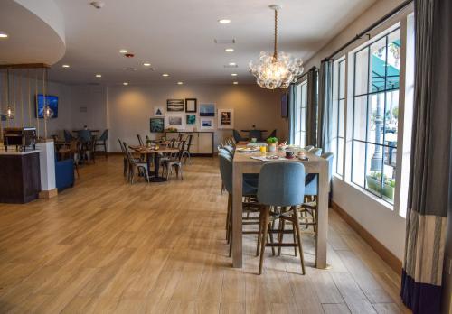 a dining room with tables and chairs and a chandelier at Beachside Inn in Santa Barbara
