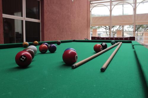a group of billiard balls and cues on a pool table at The Hill Hotéis Executive in São Carlos
