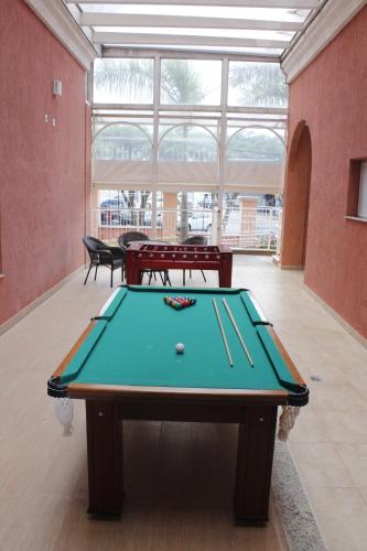 a ping pong table in a room with a pool table at The Hill Hotéis Executive in São Carlos