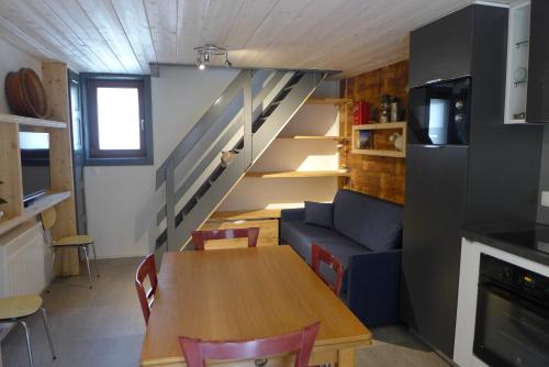 un salon avec une table et un escalier dans l'établissement Gite rural les Combes, à Thorens-Glières