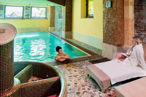 a couple of people sitting in a swimming pool at Hotel Lovere Resort & Spa in Lovere