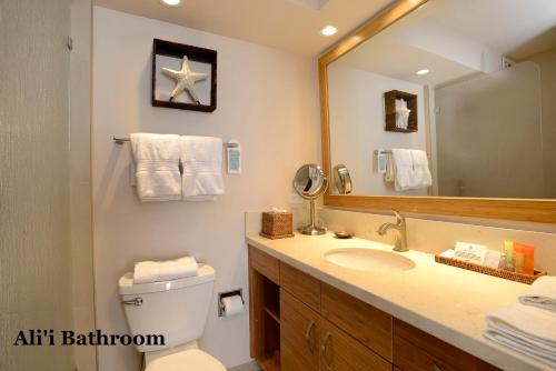 a bathroom with a sink and a mirror at Mana Kai Maui - Official Onsite Rental Company in Wailea