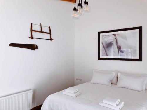 a bedroom with a white bed with two towels on it at El Establo in Puerto Natales