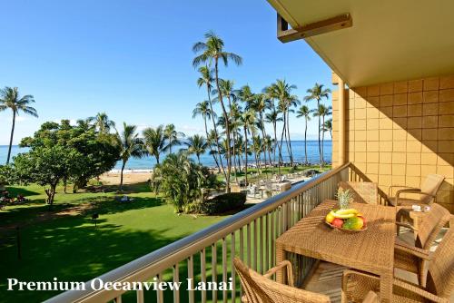 a balcony with a table and chairs and the ocean at Mana Kai Maui - Official Onsite Rental Company in Wailea