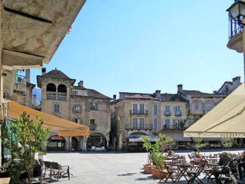 a group of tables and chairs in a courtyard with buildings at La Palma in Domodossola