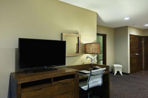 a living room with a tv and a desk at Oxford Hotel Bend in Bend