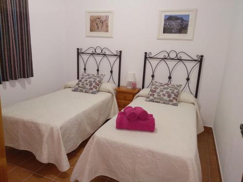 a room with two beds with a pink box on them at Casa Rural Cerca Del Caminito Del Rey Ardales in Ardales