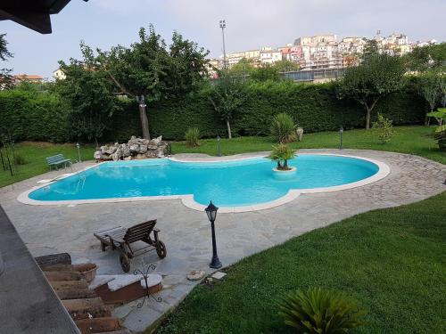 a swimming pool with a bench in a yard at Villa ARPE in Montemiletto