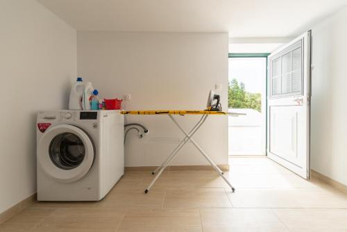 a laundry room with a washer and dryer at Casa da Figueirinha in Calheta de Nesquim