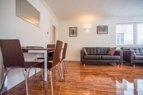 sala de estar con mesa, sillas y sofá en Superb 3-Bed 2-Bath with Wifi: Trendy Fitzrovia W1 en Londres