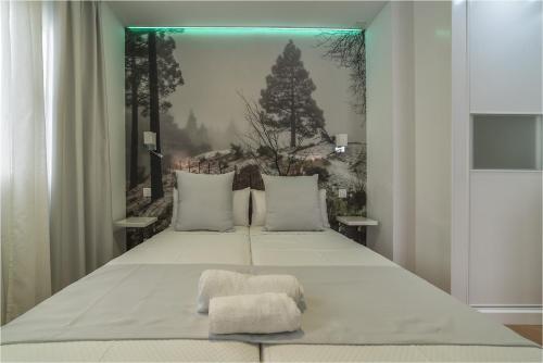 a bedroom with a large bed with a picture on the wall at Hotel Ciudad del Mar in Las Palmas de Gran Canaria