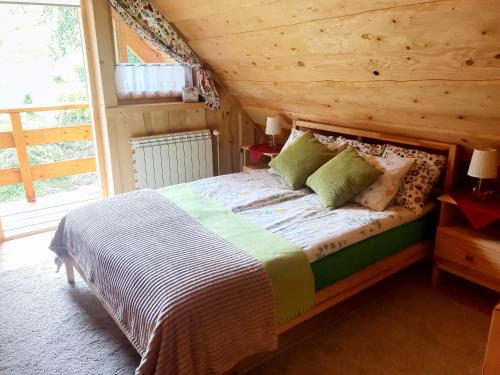 - une chambre avec un lit et un mur en bois dans l'établissement Leśniówka Domki W Karpaczu, à Karpacz