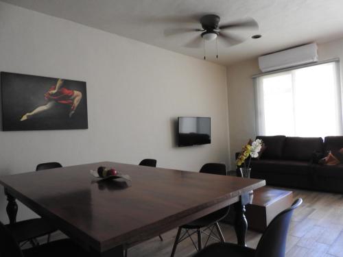 a living room with a table and a couch at Villas La Ceiba in Playa del Carmen