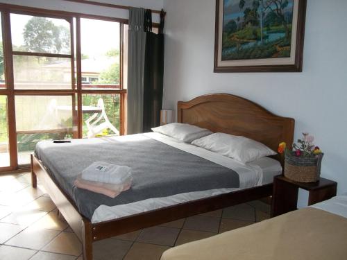 1 dormitorio con cama y ventana en Villa Pacande Bed and FreeBreakfast, en Alajuela