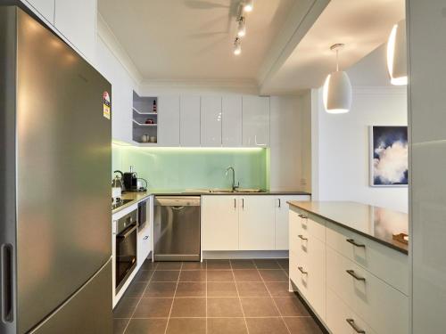 a kitchen with white cabinets and a green refrigerator at Albatross North Apartments in Gold Coast