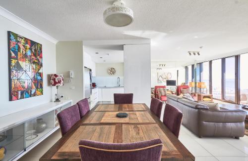 a dining room and living room with a wooden table and chairs at Albatross North Apartments in Gold Coast