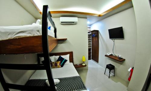 a small room with a bunk bed in a room at 4.13 Suites Hotel in Coron